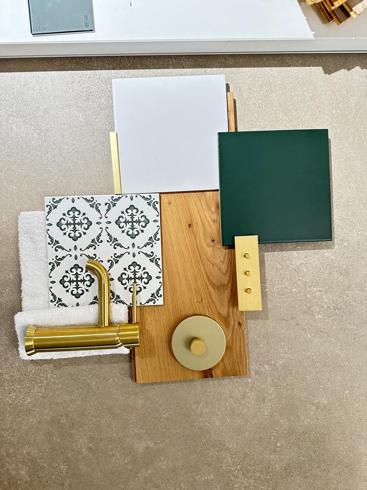 Planche de tendance au showroom : carreau décor vert, faïence blanche, parquet chêne et robinetterie laiton