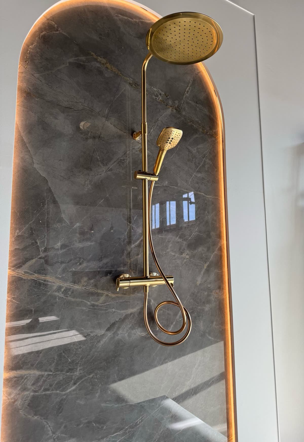 Douche dorée dans une niche en arche